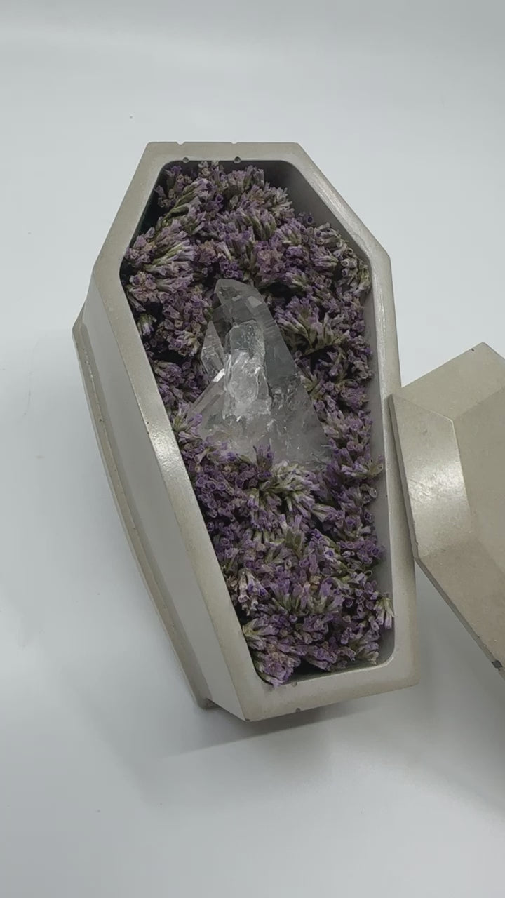 Concrete Coffin With Dried Flowers and a Clear Quartz
